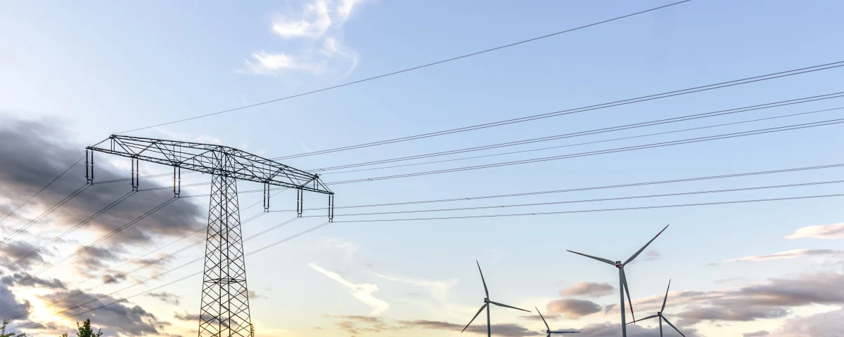 Torre eléctrica y aerogeneradores en un paisaje de energías renovables para representar el mercado energético en España