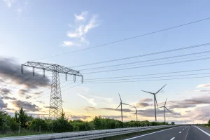 Torre eléctrica y aerogeneradores en un paisaje de energías renovables para representar el mercado energético en España