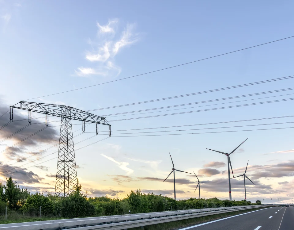 Torre eléctrica y aerogeneradores en un paisaje de energías renovables para representar el mercado energético en España