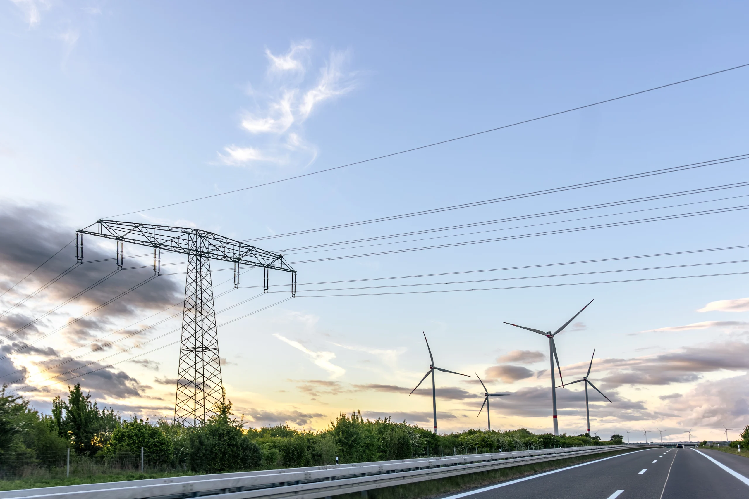 Torre eléctrica y aerogeneradores en un paisaje de energías renovables para representar el mercado energético en España